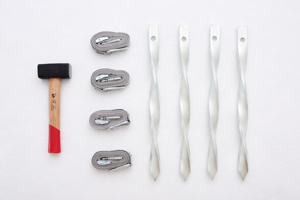 Fastening kit set of 4 consisting of 1 hammer, 4 tension straps and 4 pegs.